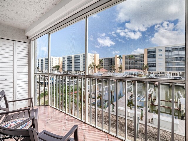 sunroom featuring a water view