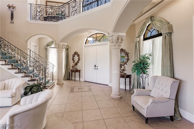 tiled entrance foyer featuring a high ceiling and decorative columns