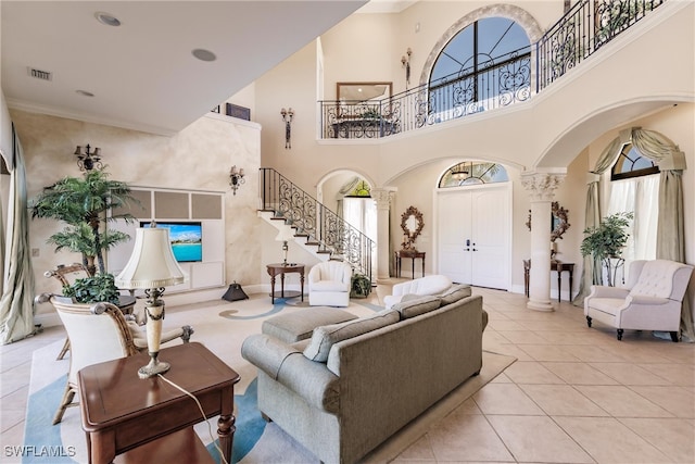 tiled living room with decorative columns and a towering ceiling