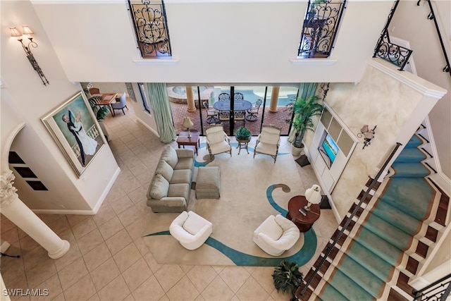 living room with decorative columns and tile patterned flooring