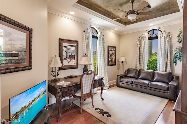 sitting room featuring ornamental molding, hardwood / wood-style floors, ceiling fan, and a raised ceiling