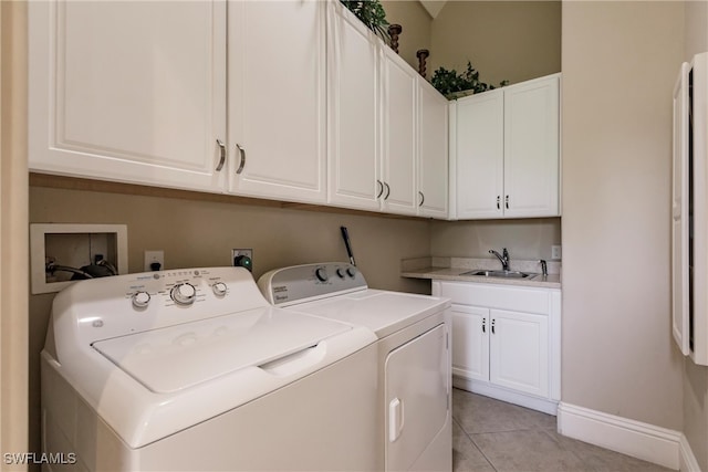 washroom featuring cabinets, washing machine and dryer, sink, and light tile patterned flooring