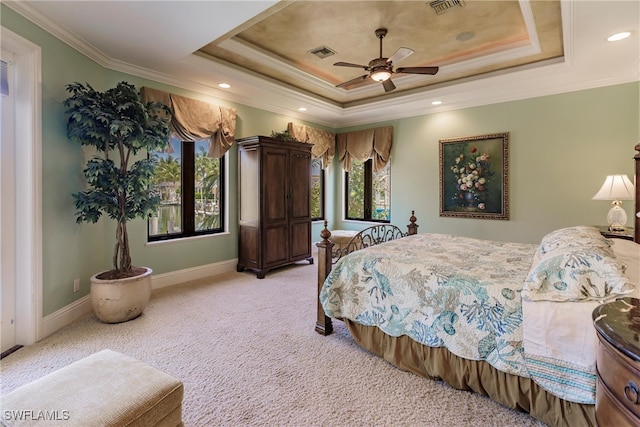 carpeted bedroom with ornamental molding, ceiling fan, and a raised ceiling