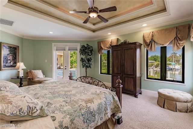 bedroom with a tray ceiling, light colored carpet, ceiling fan, and access to exterior