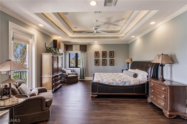 bedroom featuring dark wood-type flooring, multiple windows, ceiling fan, and a raised ceiling