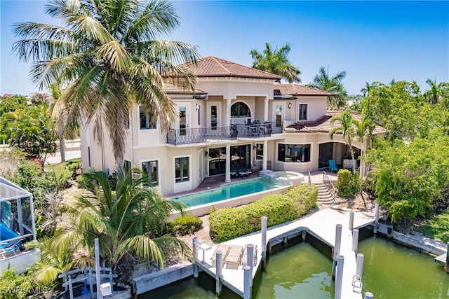 rear view of house featuring a water view, a balcony, and a patio area