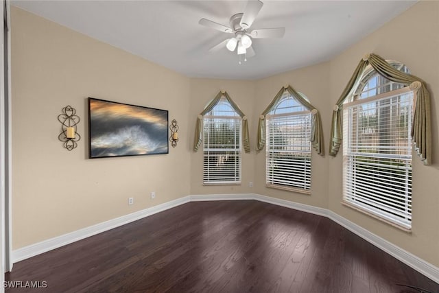 spare room featuring a ceiling fan, baseboards, and wood finished floors