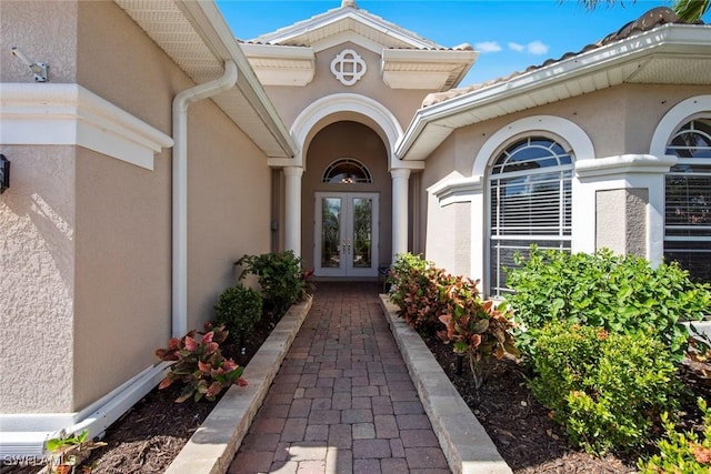 property entrance with stucco siding and french doors