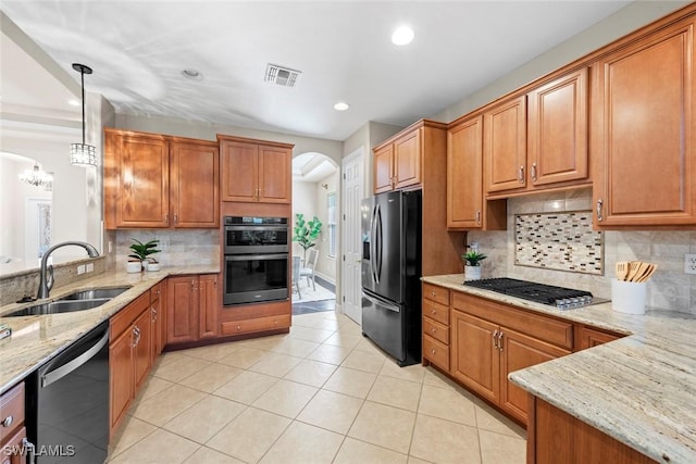 kitchen featuring light tile patterned floors, stainless steel appliances, a sink, visible vents, and light stone countertops