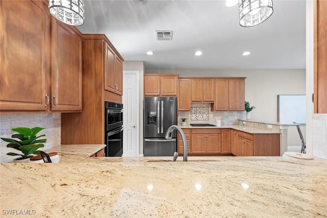 kitchen with visible vents, light stone counters, a peninsula, black appliances, and a sink