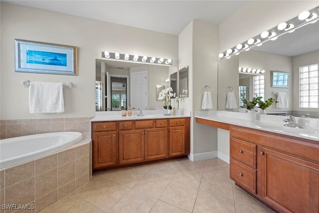 full bath featuring two vanities, a garden tub, a sink, and tile patterned floors