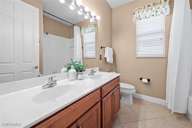 bathroom featuring toilet, tile patterned flooring, baseboards, and a sink