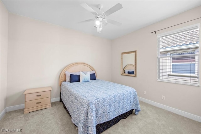 bedroom featuring baseboards, a ceiling fan, and light colored carpet