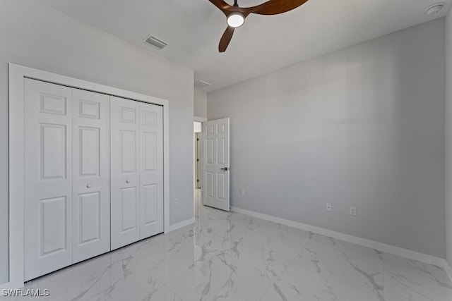 unfurnished bedroom with ceiling fan and a closet