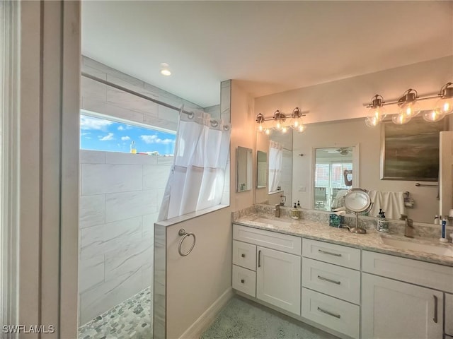 bathroom with curtained shower, vanity, and a healthy amount of sunlight