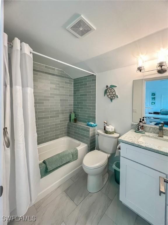 full bathroom with shower / bath combination with curtain, toilet, and vanity