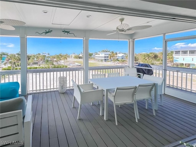 sunroom featuring ceiling fan and plenty of natural light