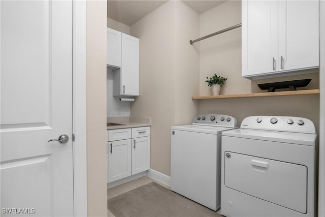 washroom featuring cabinets and washing machine and dryer