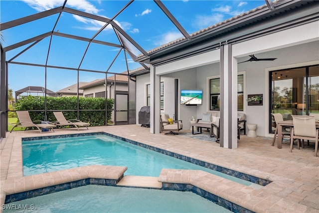 view of pool with a patio, ceiling fan, and a lanai