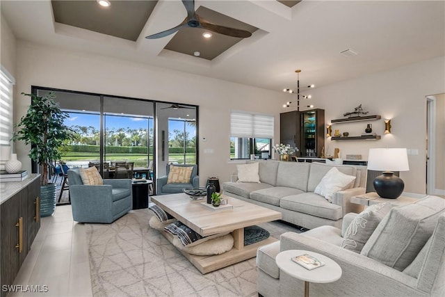 living room with beam ceiling, ceiling fan with notable chandelier, and coffered ceiling