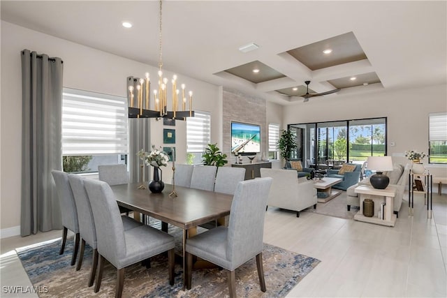 dining space featuring beam ceiling, coffered ceiling, a high ceiling, and ceiling fan with notable chandelier