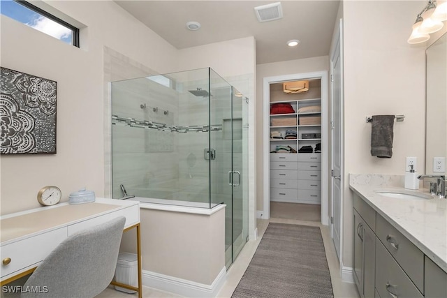 bathroom featuring tile patterned flooring, vanity, and a shower with door