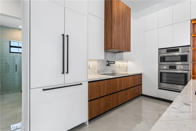 kitchen featuring backsplash, light stone counters, stainless steel double oven, high end white refrigerator, and white cabinetry