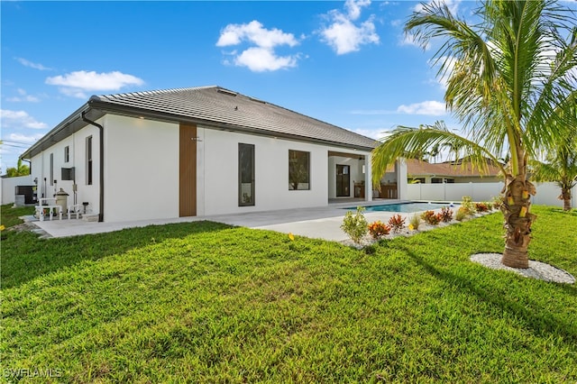 rear view of property featuring a lawn and a patio area