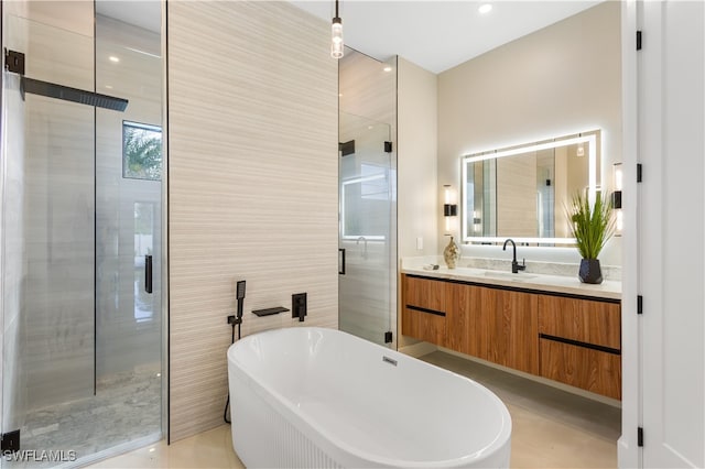 bathroom featuring vanity and independent shower and bath