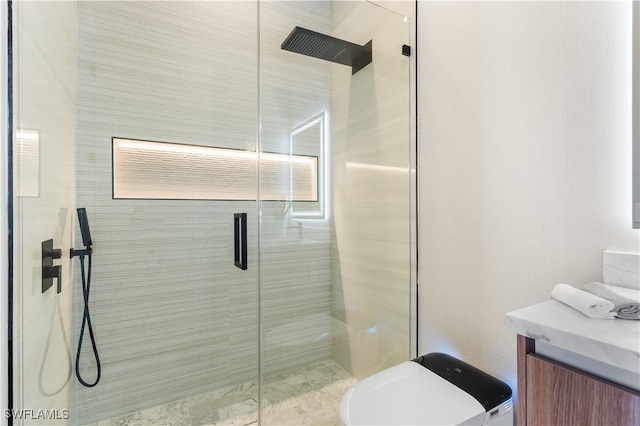 bathroom with vanity, toilet, and a shower with shower door