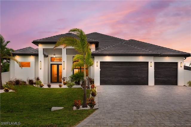 prairie-style house with a garage and a lawn