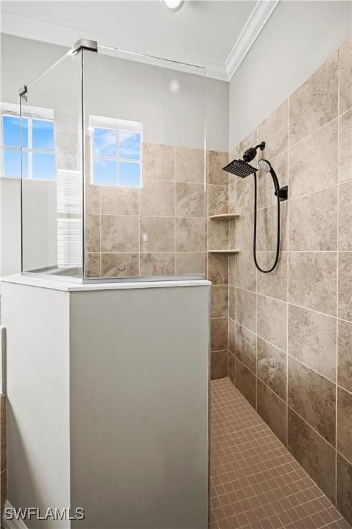 bathroom featuring tiled shower, plenty of natural light, and ornamental molding