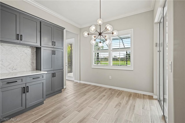 kitchen with ornamental molding, gray cabinetry, pendant lighting, light hardwood / wood-style flooring, and a chandelier