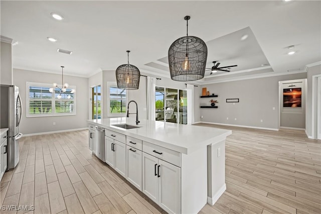 kitchen with sink, hanging light fixtures, stainless steel appliances, a center island with sink, and ceiling fan with notable chandelier