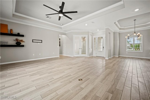 unfurnished living room featuring a raised ceiling, crown molding, and ceiling fan with notable chandelier