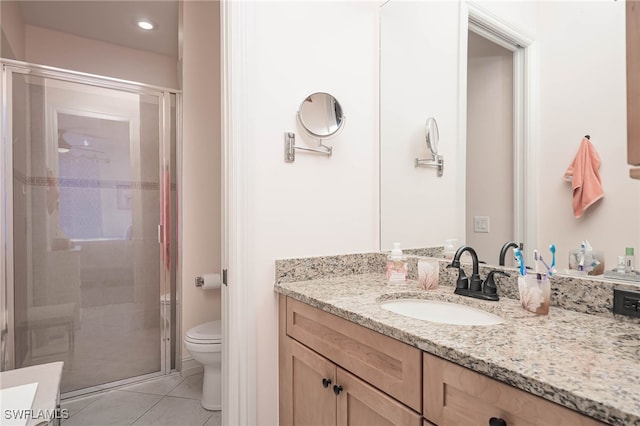 bathroom featuring tile patterned flooring, vanity, toilet, and walk in shower