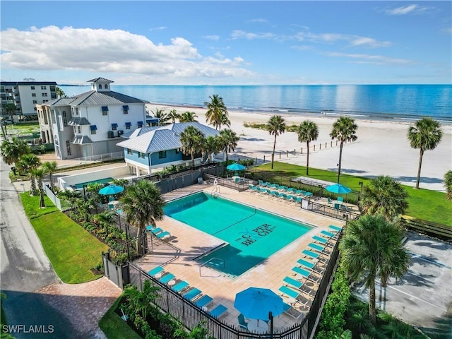 view of swimming pool featuring a beach view, a water view, and a patio