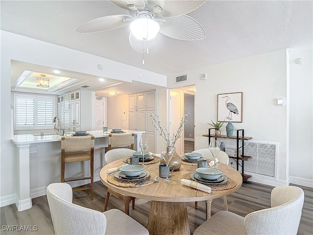 dining space with ceiling fan and hardwood / wood-style flooring