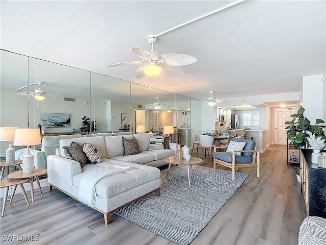 living room with ceiling fan and light hardwood / wood-style floors