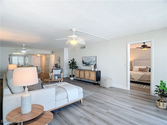 living room with light hardwood / wood-style floors and ceiling fan