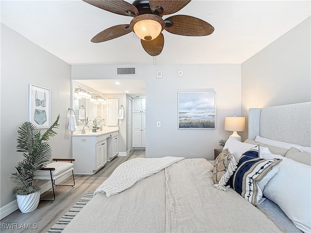 bedroom with ceiling fan, light wood-type flooring, and ensuite bathroom