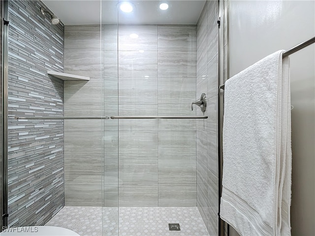 bathroom featuring a shower with shower door and toilet