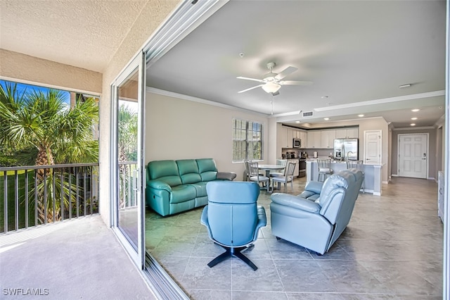 living room featuring ceiling fan and crown molding