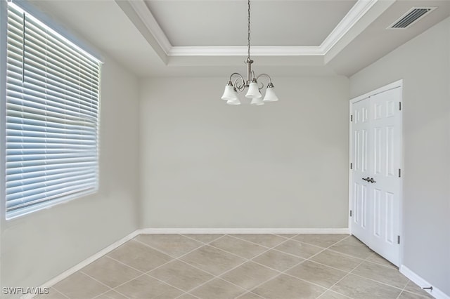 empty room featuring a raised ceiling, light tile patterned floors, crown molding, and a chandelier