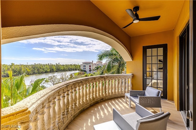 balcony featuring a water view and ceiling fan