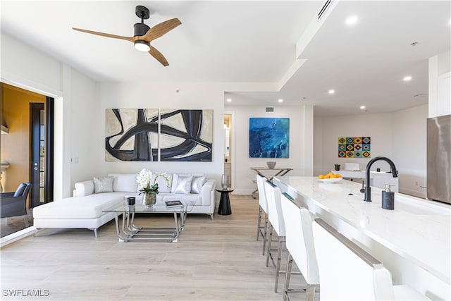 living room with light hardwood / wood-style floors and ceiling fan