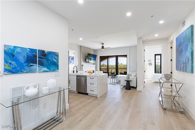 kitchen with white cabinetry, ceiling fan, stainless steel dishwasher, and light hardwood / wood-style floors