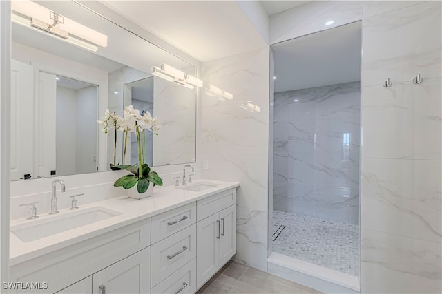 bathroom featuring a tile shower, vanity, and tile walls