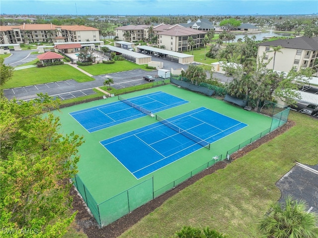 view of tennis court with a water view