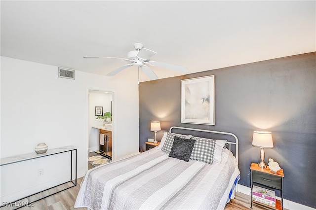 bedroom featuring connected bathroom, ceiling fan, and light wood-type flooring